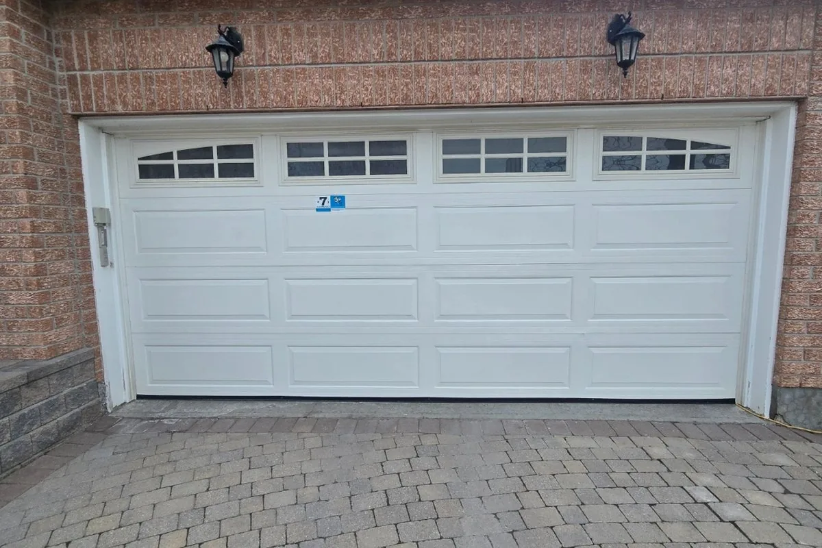 White raised-panel garage door on a Convent Glen single-car townhome